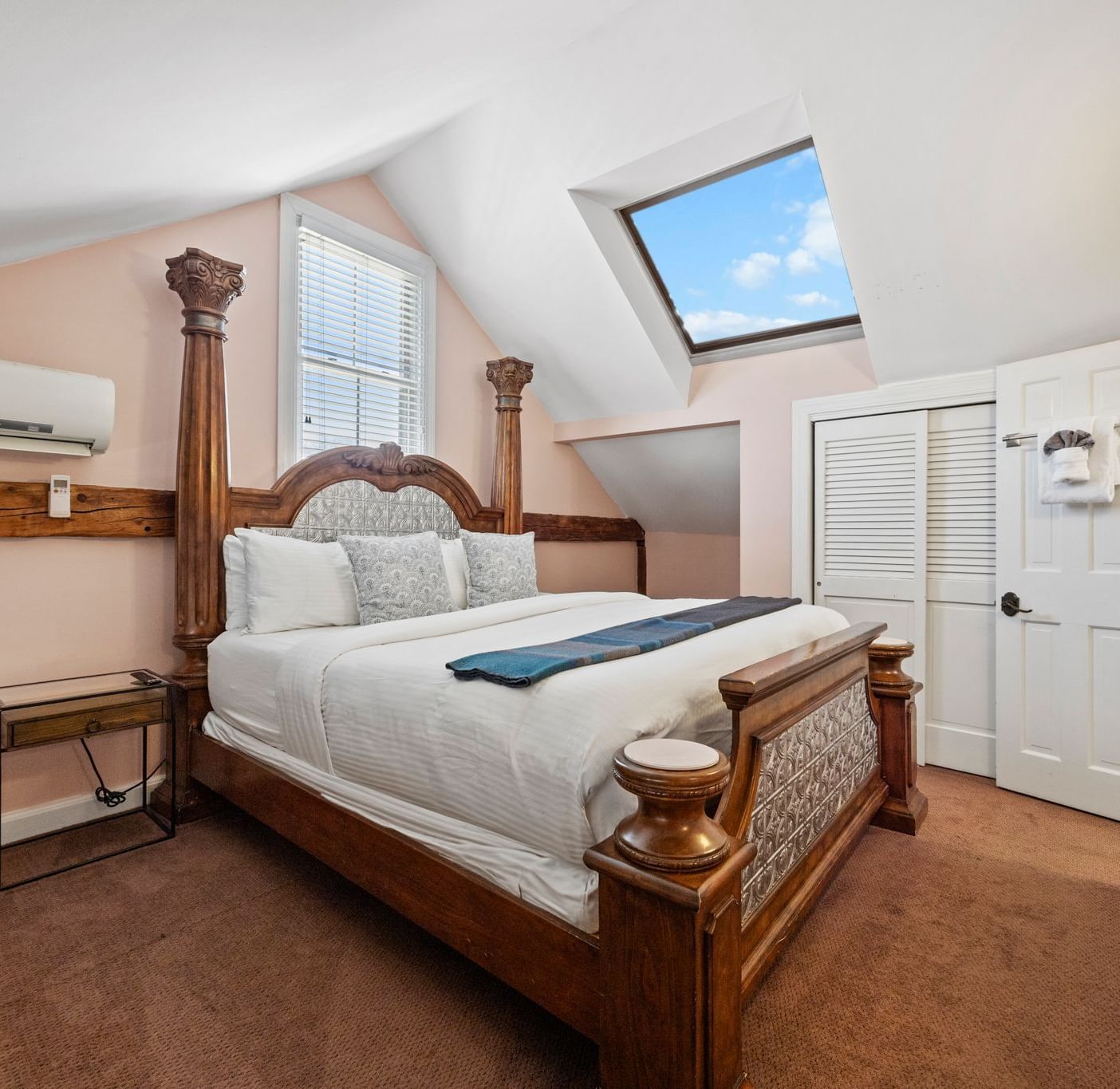 A bedroom with four-poster bed, flat screen TV, and traditional furnishings at Hartstone Inn