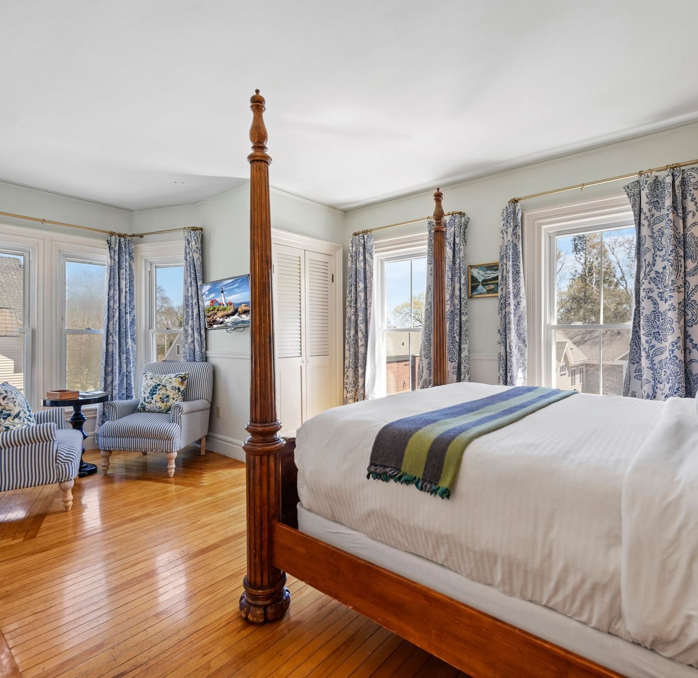 Elegant room with glass windows and dark wood four-poster bed at Hartstone Inn