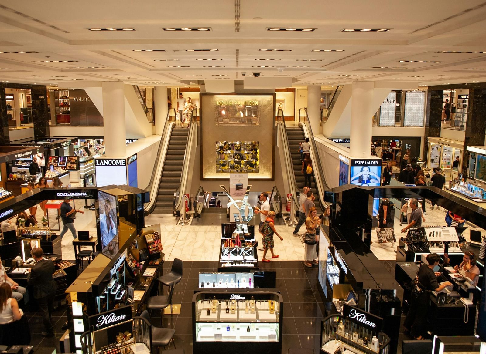 An interior view of a mall with multiple floors where people are gathered.