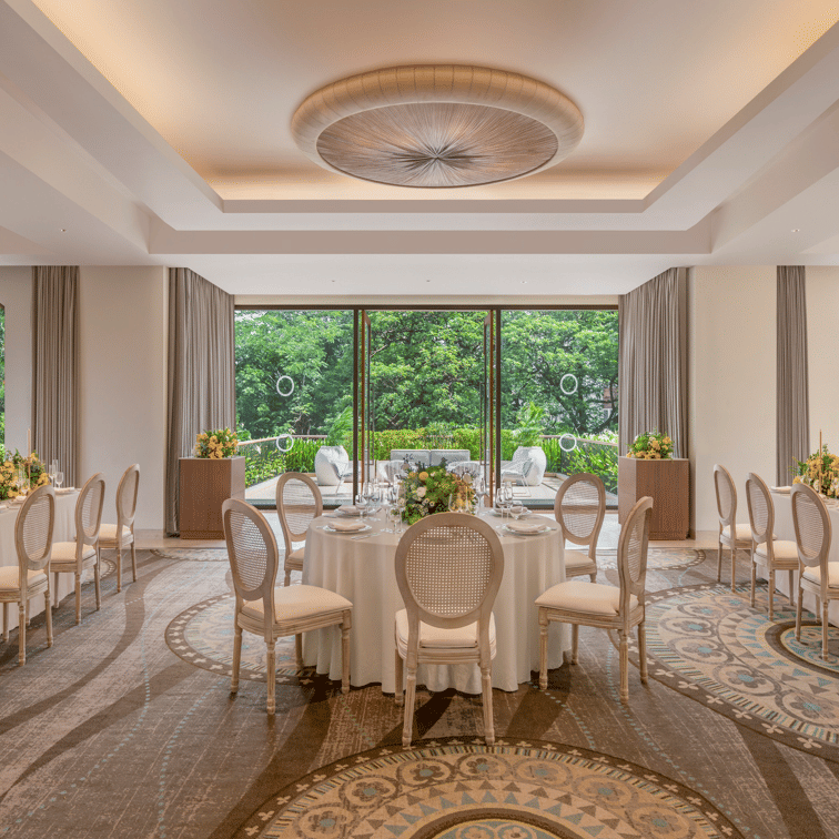 Dining hall with arranged tables, chairs, and large windows at The Raintree, St. Mary’s Road.