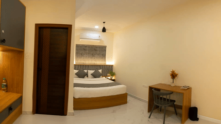 A wide view of premium room, featuring open wardrobe, work desk, and a double bed | Hotel Aurora Bliss, Gachibowli