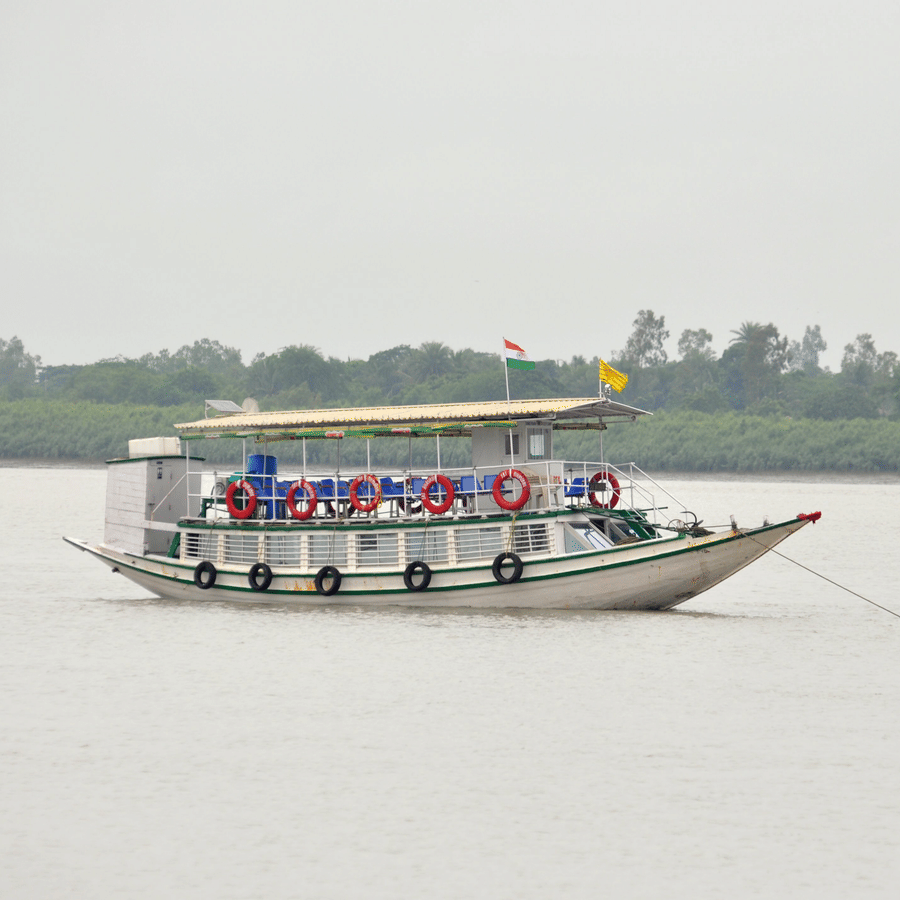 A boat floating on a river and at the horizon there are trees in a far away land.