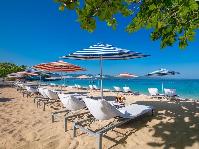 An image of a beach seen from the shade of trees - S Hotel Montego Bay, Jamaica