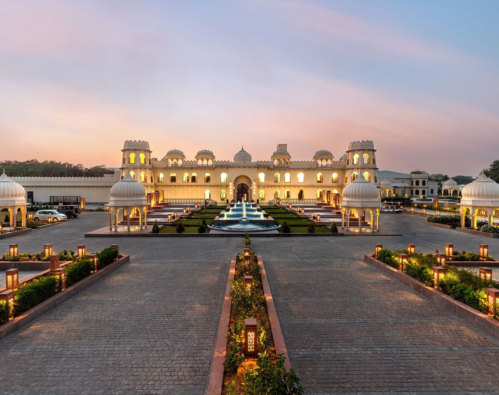 Exterior view of Kesar Bagh Palace building at sunset with landscaped pathways.