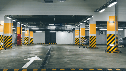 An empty parking lot with beams having reflective stickers on them.