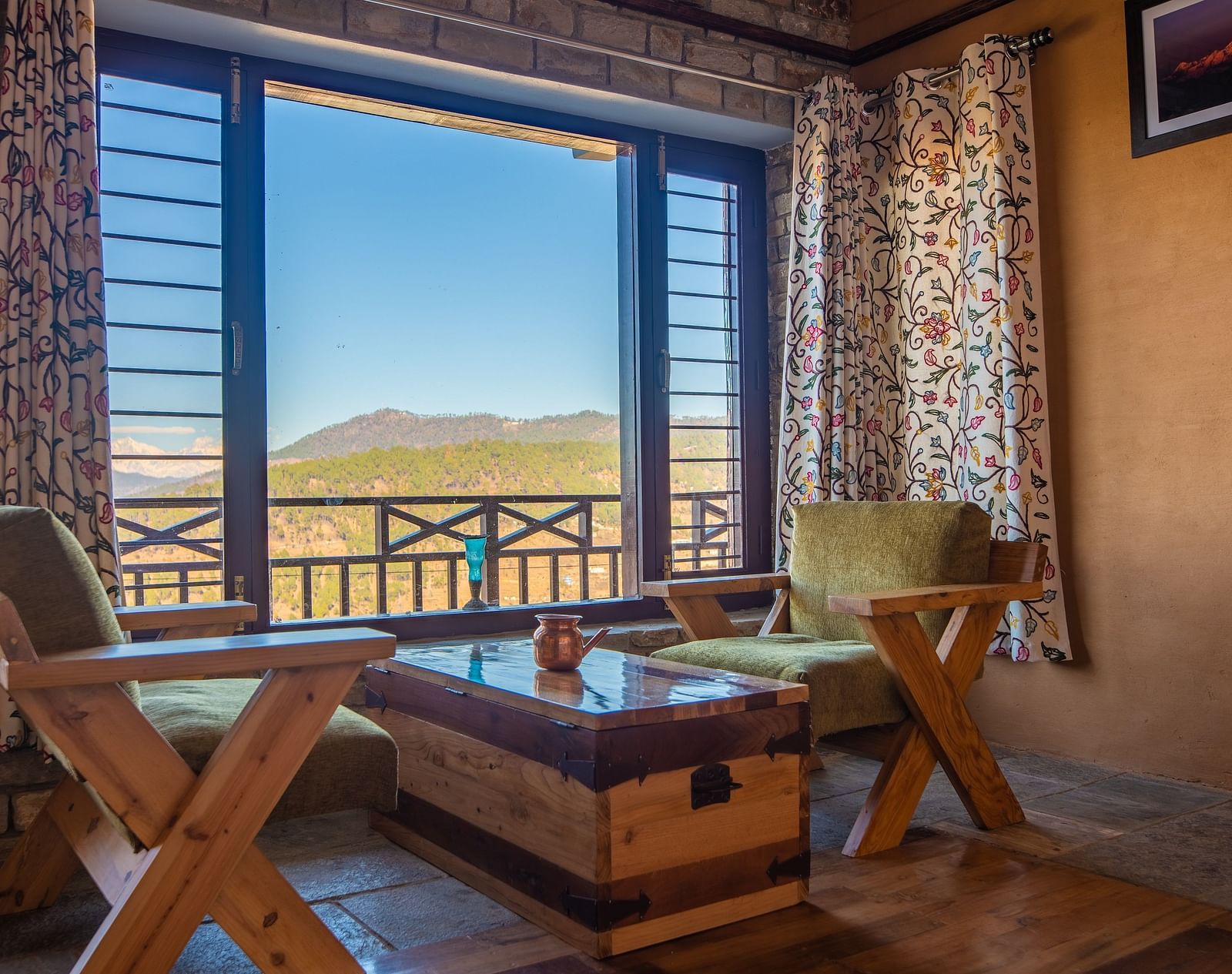 Cosy seating area by a large window overlooking a green valley and distant hills. - Blusalzz Homes The Himalayan Bungalow, Almora