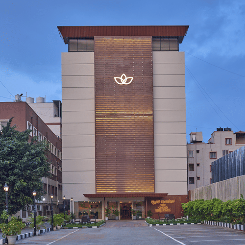 An evening view of our hotel facade with our hotel logo illuminated by warm yellow lights - Grand Continent, Brookefield