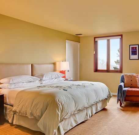 A peaceful bedroom setting with a double bed, a TV and windows with views, offering a perfect retreat for relaxation and comfort - Brewery Gulch Inn & Spa