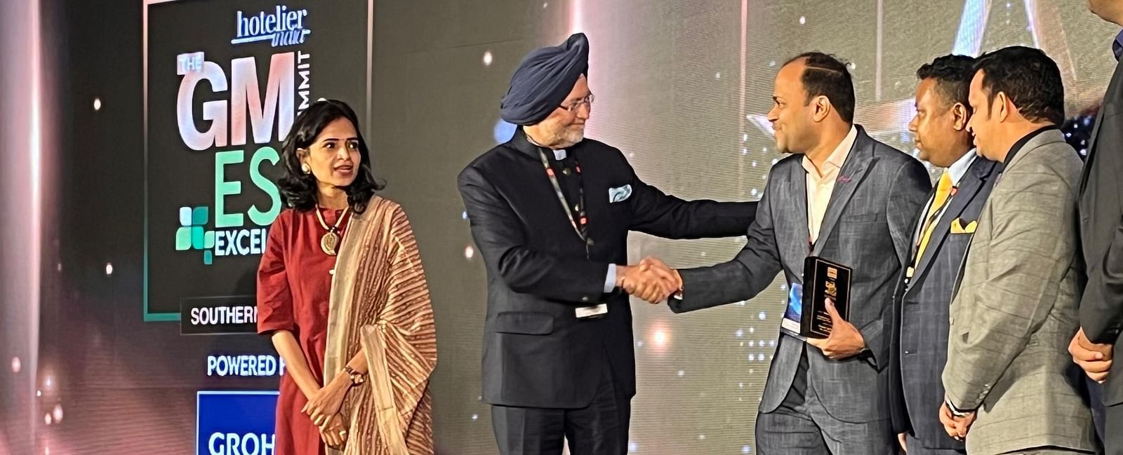 Chief guest congratulating the winner in an award ceremony.