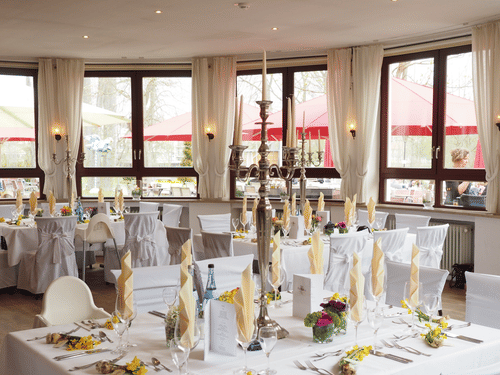 a banquet hall where tables and chairs are covered in white sheets