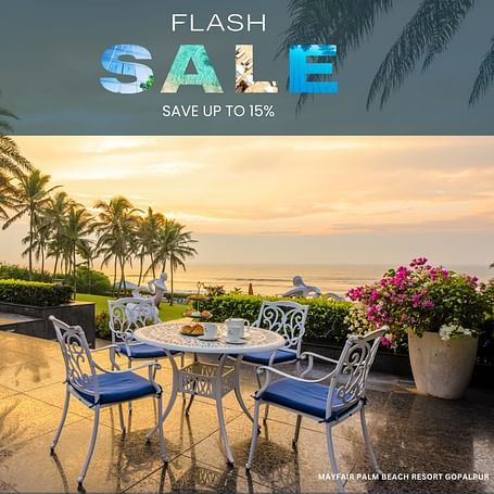 A tranquil beachside patio setting with a table and chairs, inviting guests to enjoy a relaxing stay at Mayfair Palm Beach Resort Gopalpur during their Flash Sale