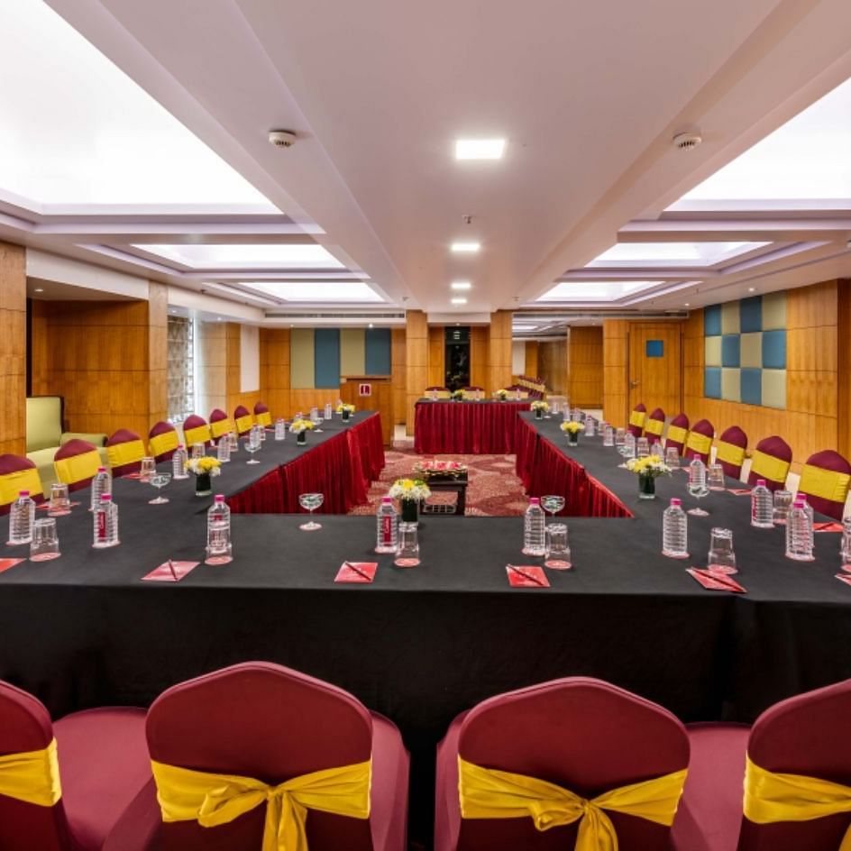 a large boardroom with U-shaped seating arrangements  with wood-panelled walls and ceiling lights at Libra Lords Inn Jaipur
