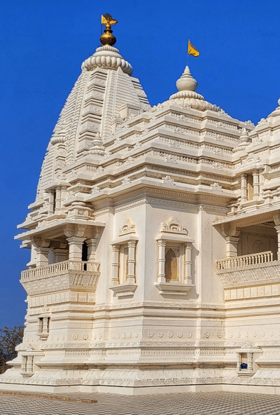 A temple stands with a spire and carvings under the sky.