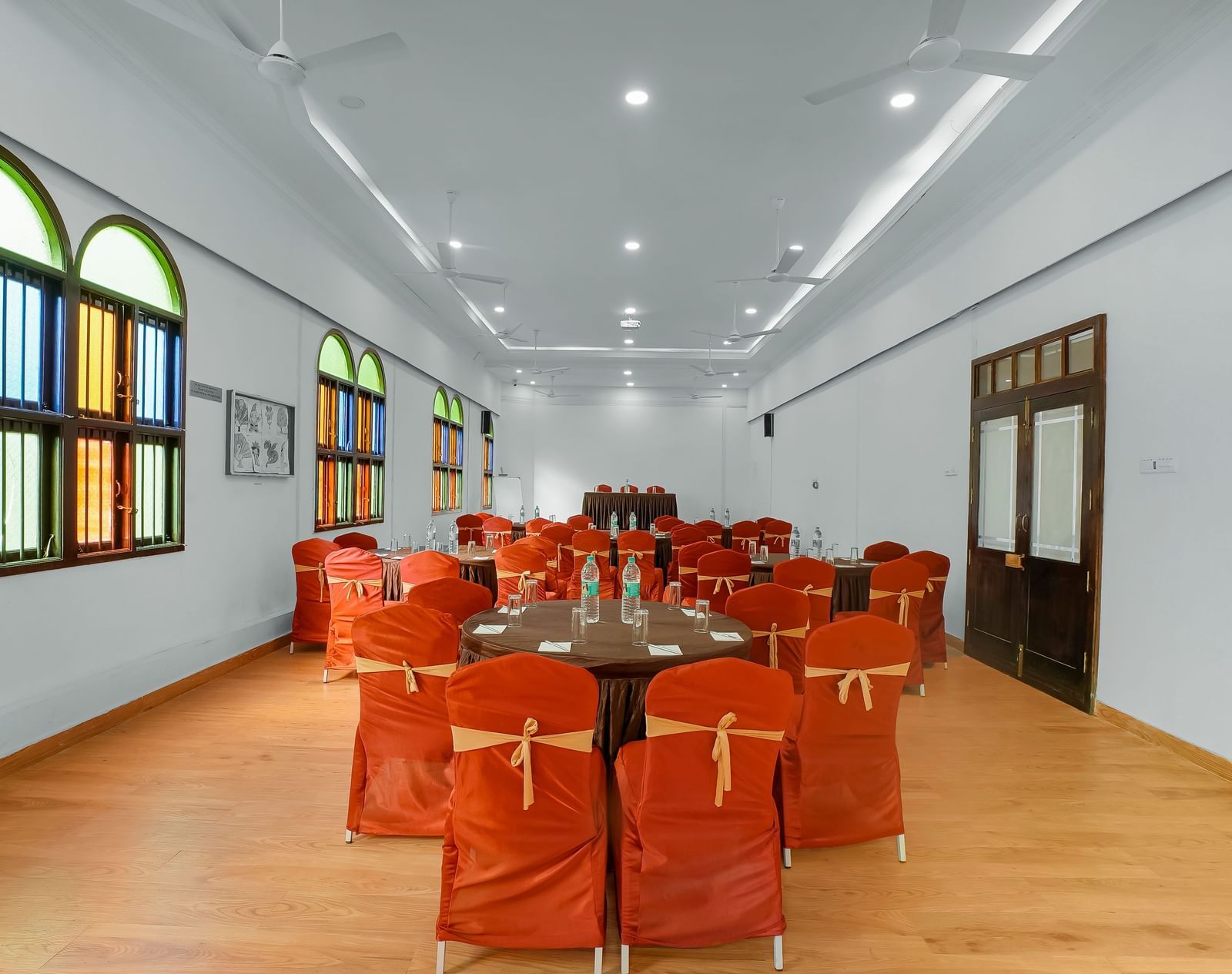 Back view of banquet hall with chairs arranged around a round table at WOW Bungalow, Yercaud.