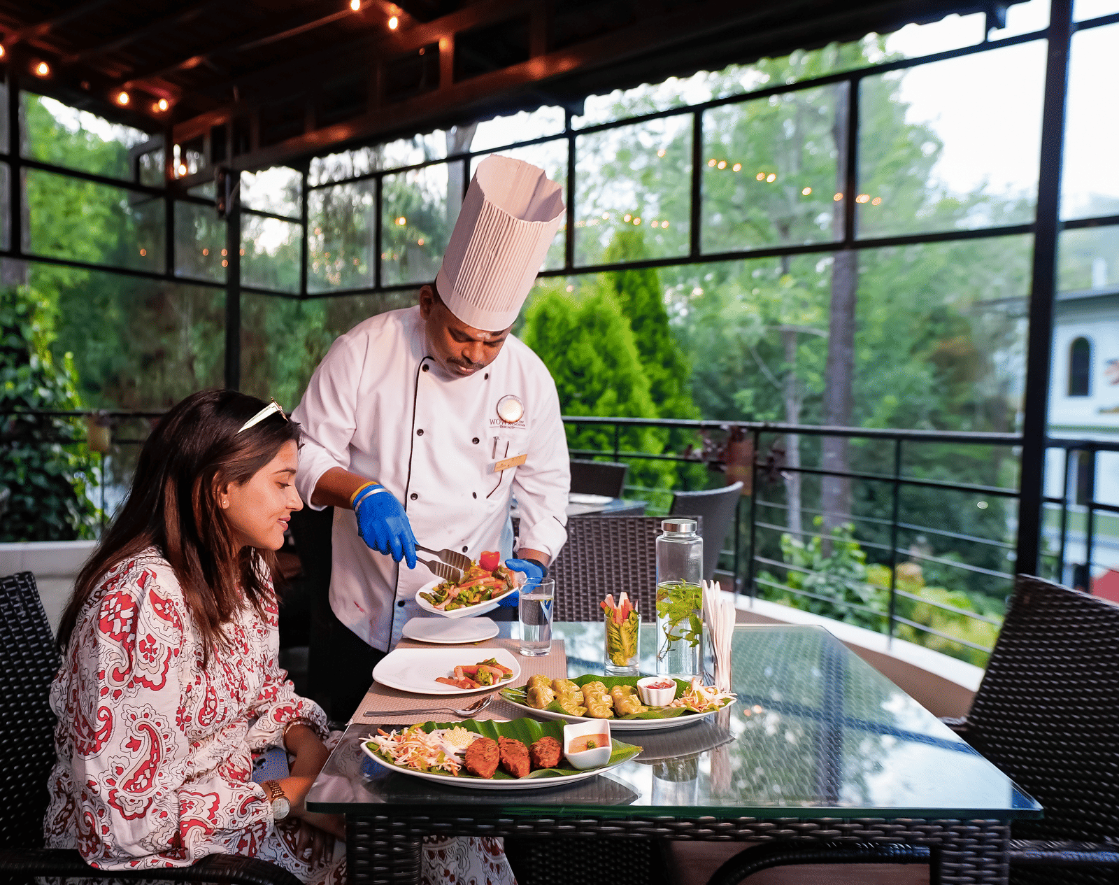 A chef serving food to a lady at WOW Bungalow, Yercaud.