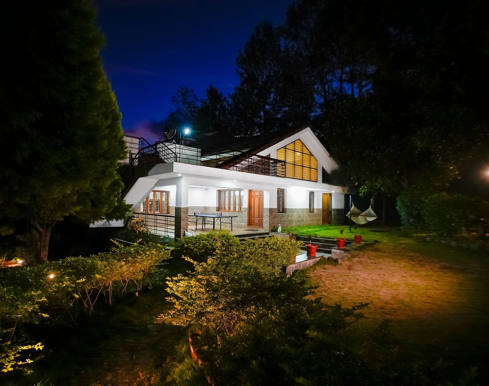 Facade view of WOW Bungalow, Yercaud, at night with a garden area.