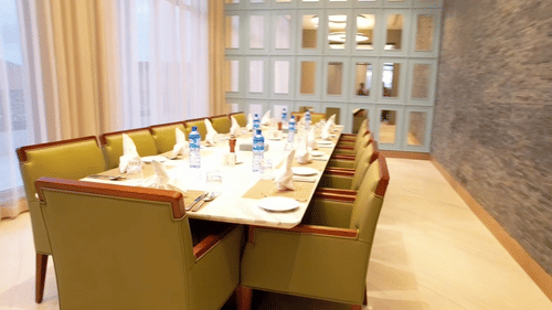 Private dining room in Hargeisa featuring long table, cushioned chairs, and floor-to-ceiling windows - Serene Sarovar Premiere Hargeisa