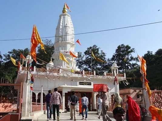 A Hindu temple with flags and decorations stands at an entrance.