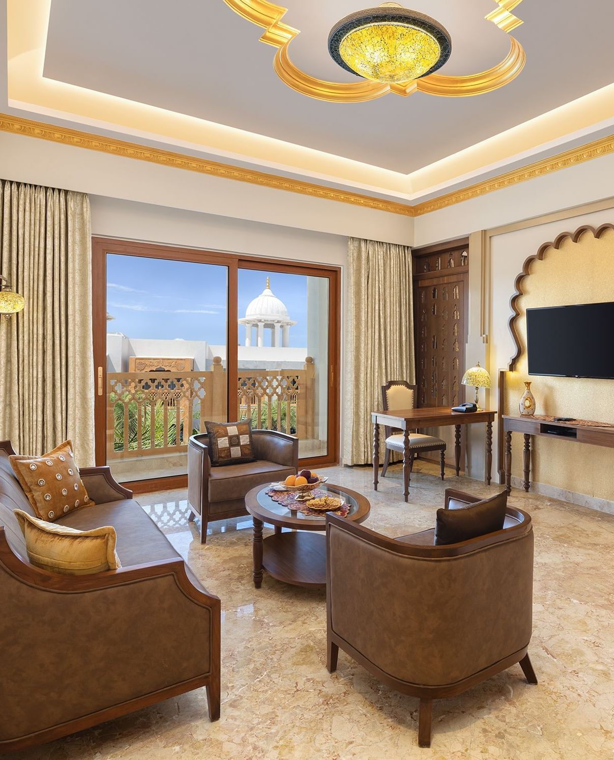 A seating area in our suite in Mahabalipuram with large windows, neutral tones, and cosy armchairs - Kaldan Samudhra