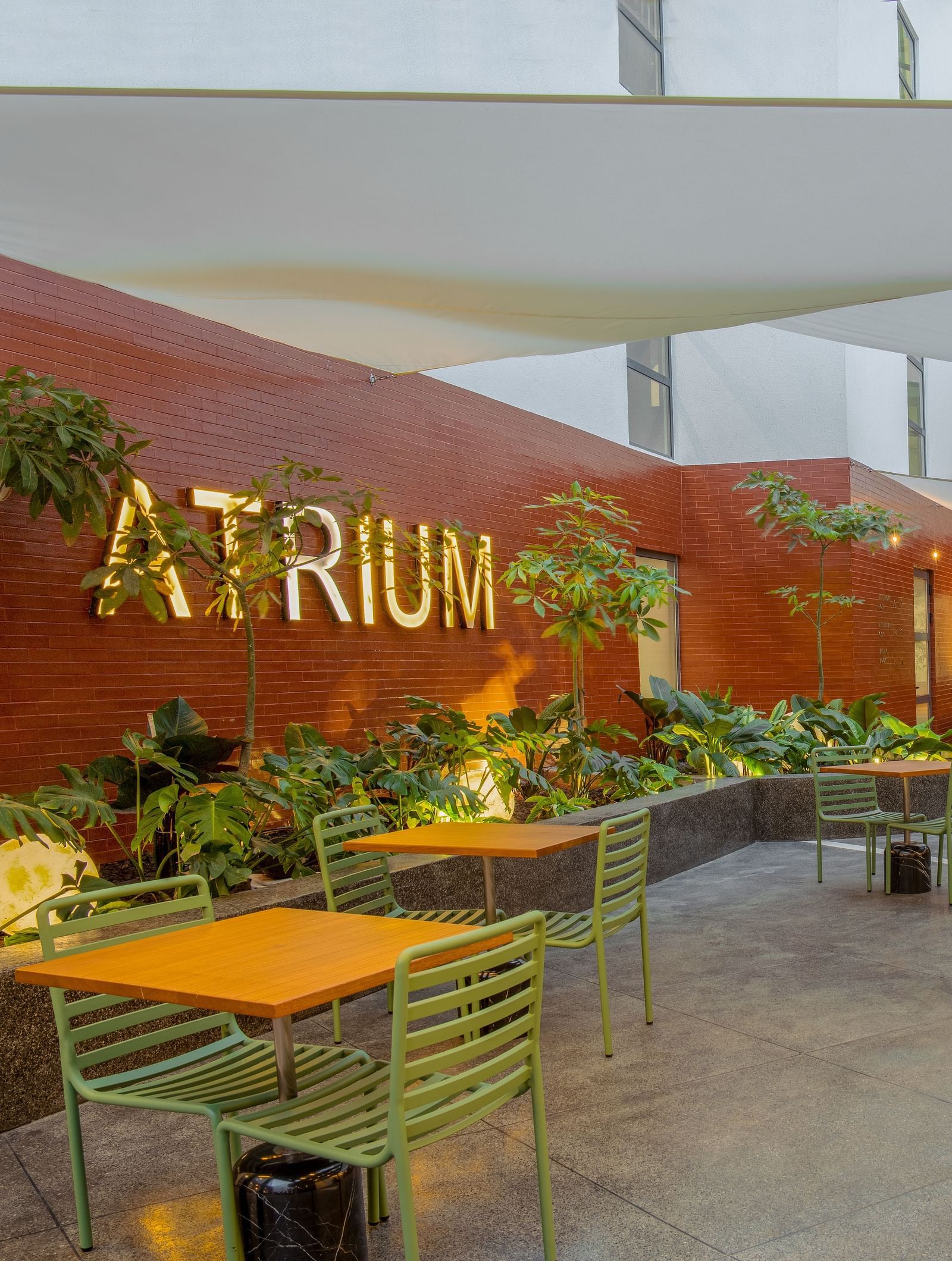 Atrium restaurant at The Pelican Hotel, Accra, featuring shaded seating and a contemporary courtyard vibe.