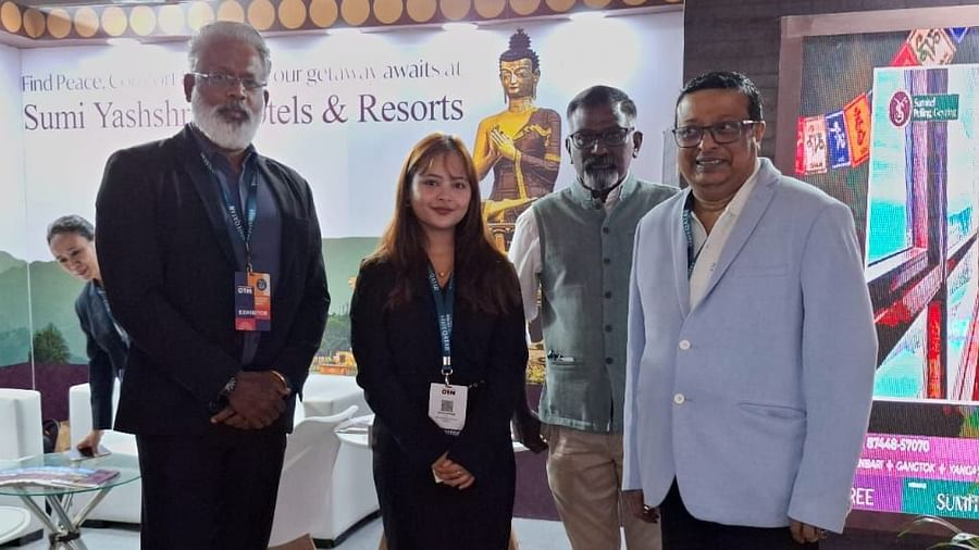 Group photo at a promotional booth for Sumi Yashshree Hotels & Resorts, featuring team members and associates in a professional setting