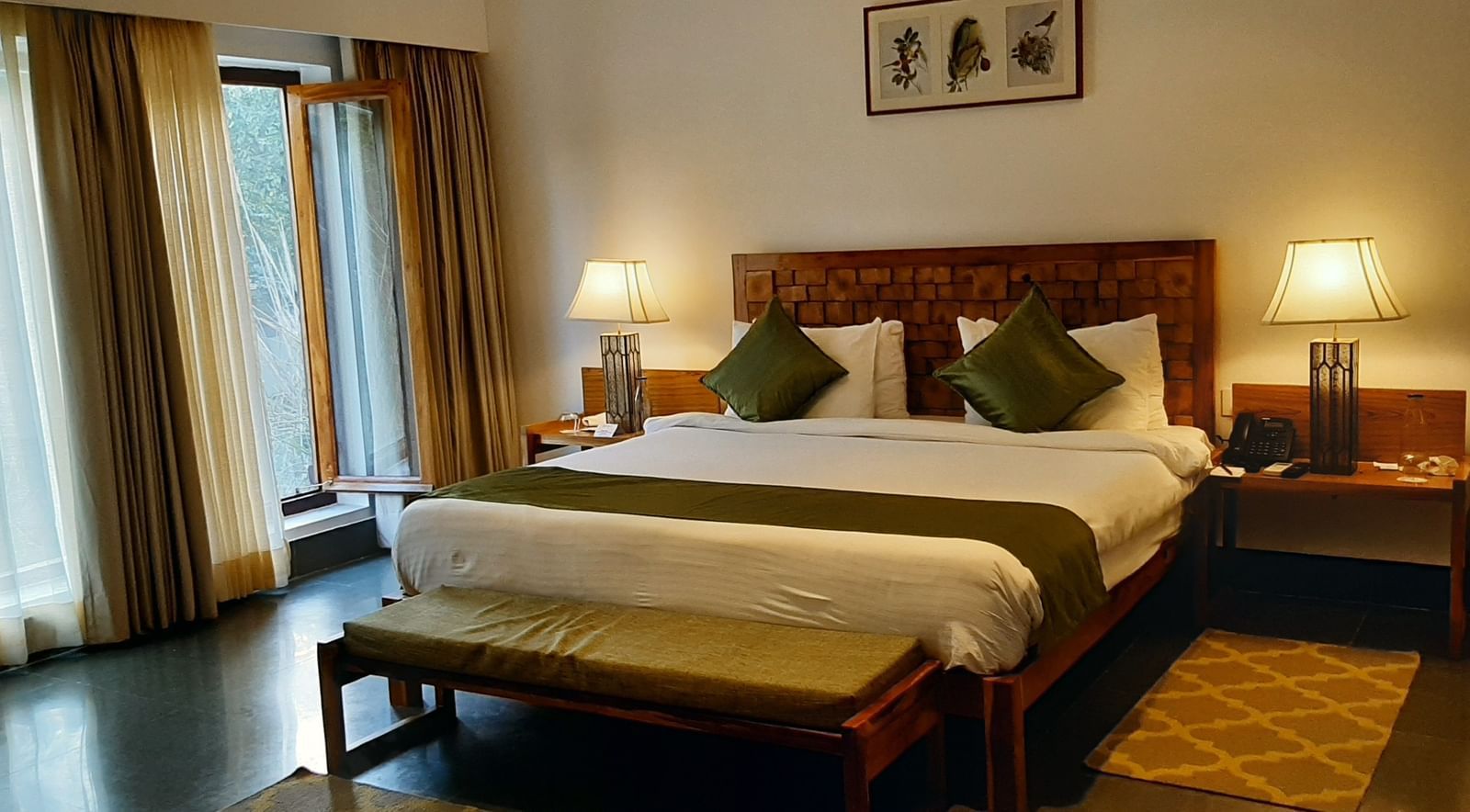 A room at Saraca Resort & Spa Corbett with a double bed and large French windows