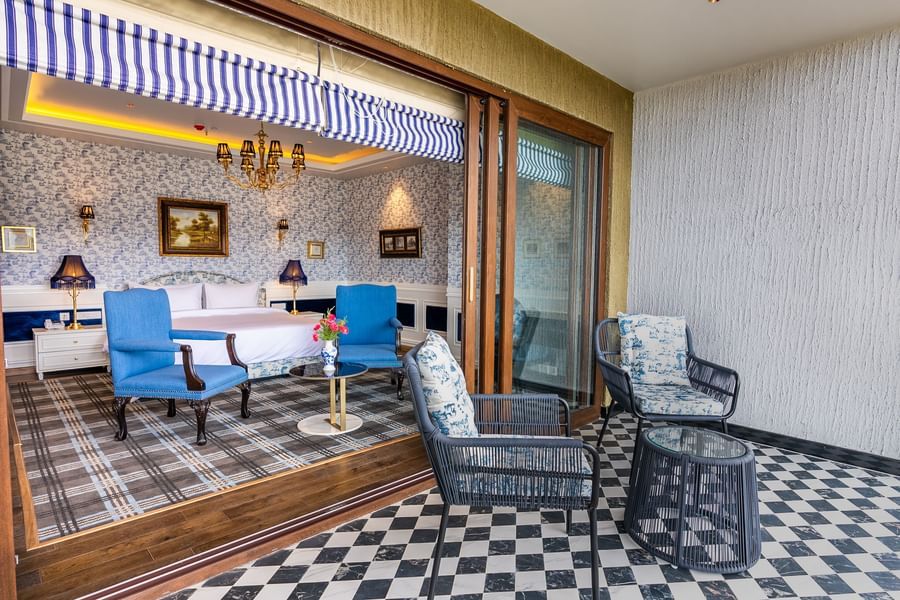 A hotel room with a large bed, comfy chairs and a balcony  - The Manor Luxury Hotel, Shimla