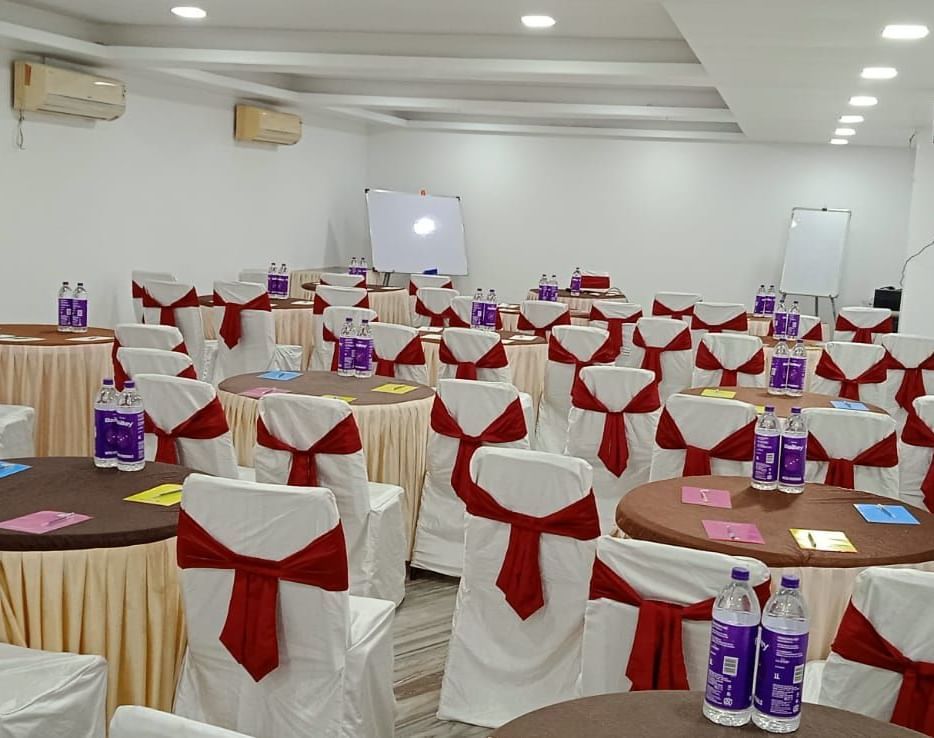 Round tables and chairs covered with cloth, and warm overhead lighting enhance and reside in the Emerald banquet hall of Mountview Resort.