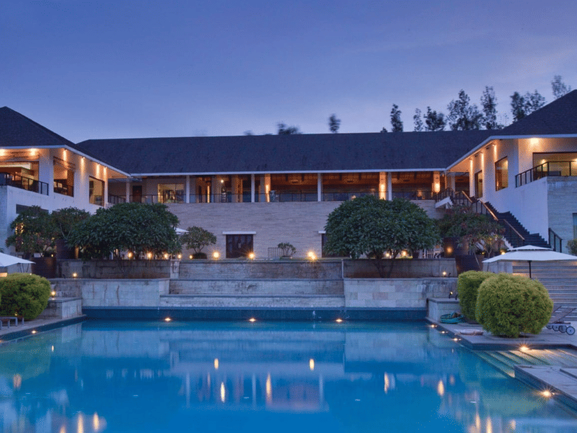 An image of the exterior facade of The Serai Chikmagalur in the evening.