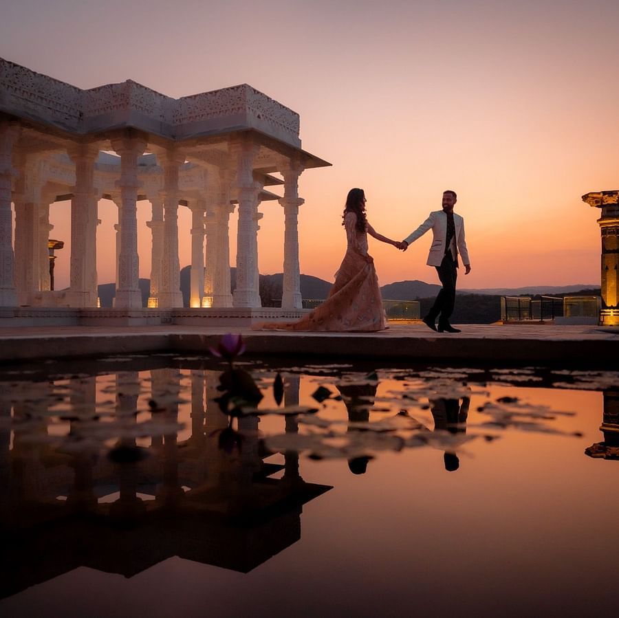 Couple holding hands at sunset near elegant marble pavilion at Fateh Vilas Collection Udaipur