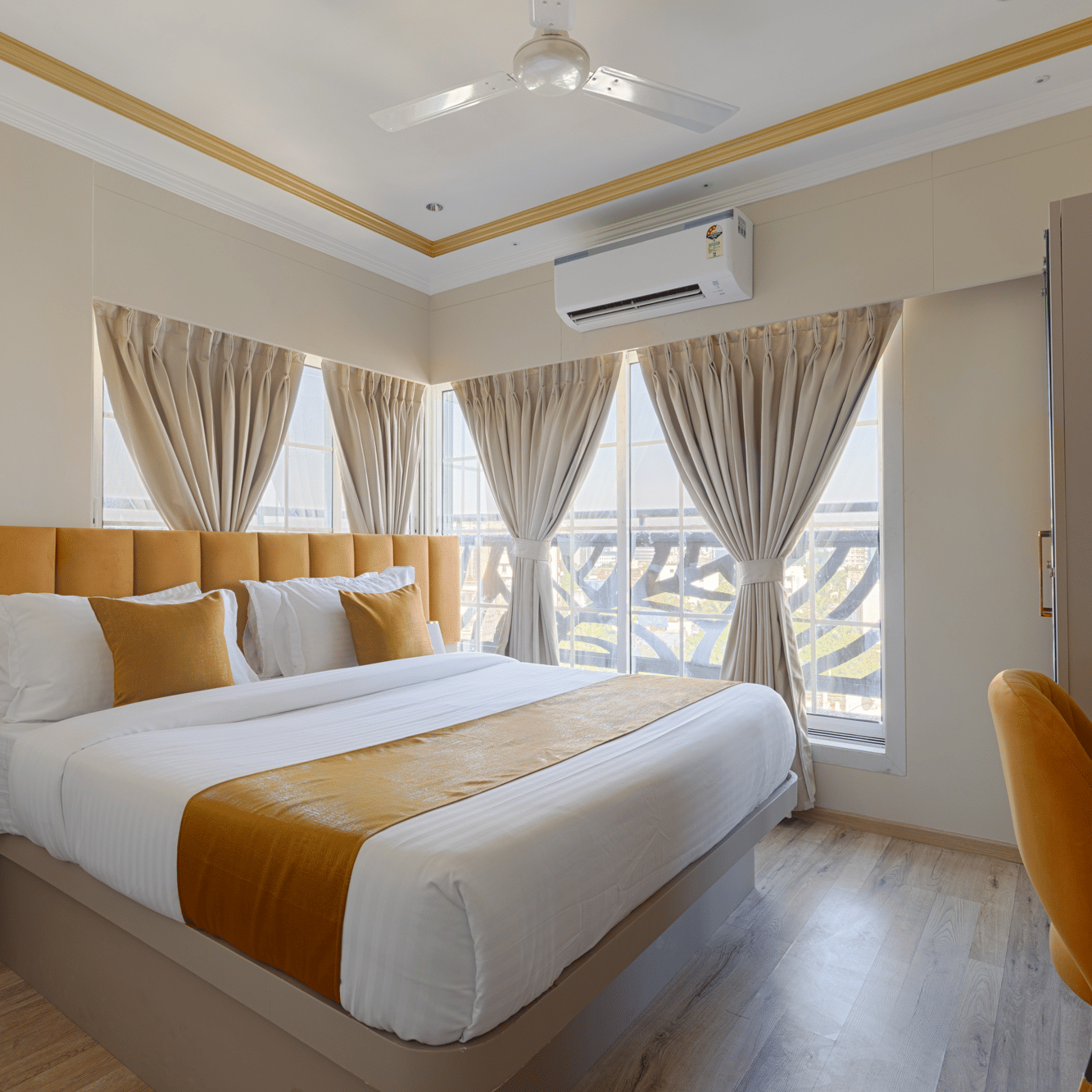 A sunny bedroom with large windows, light brown curtains, and a work desk - Home2 Residency, Mumbai Airport