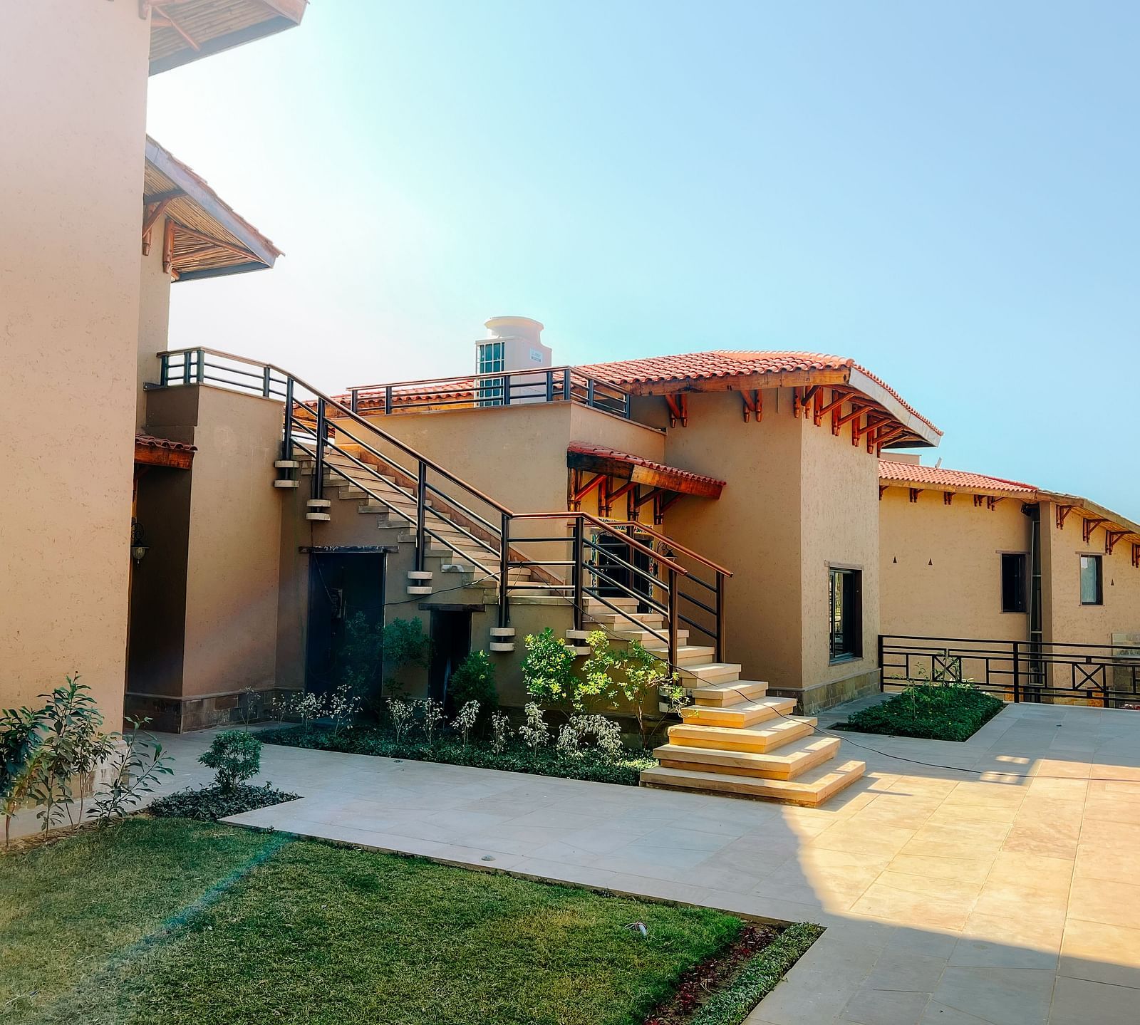 A cluster of beautifully designed resort buildings with outdoor staircases at Aamaghati Wildlife Resort.