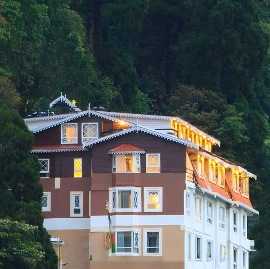 Front facade view of Summit Hermon Hotel & Spa, Darjeeling, surrounded by lush greenery