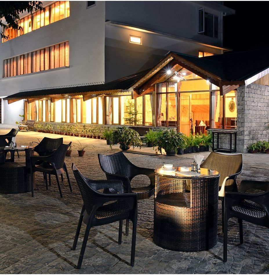 Comfortable seating with tables placed in front of the hotel.