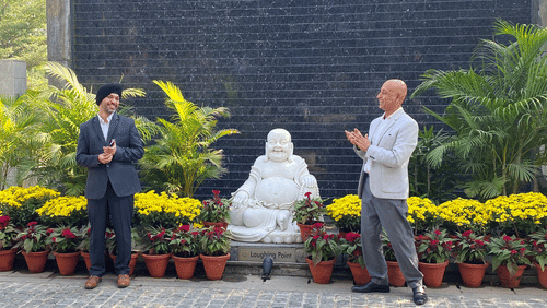 A group of people talking in front of potted plants - Karma Lakelands.