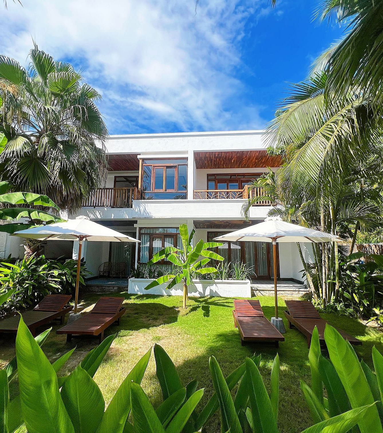 A serene view of one of our accommodations covered in lush greenery seen on a sunny day - Alibu Resorts Nha Trang