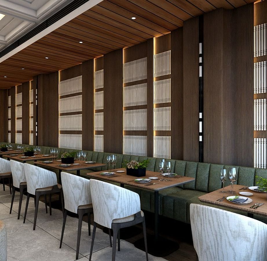 A long green coloured sofa lined with several dining tables along with grey coloured cushioned chairs - Namaste Corbett