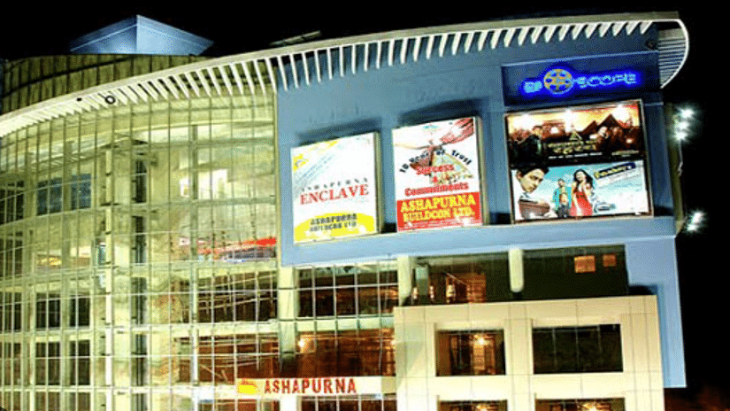 A close view of Ashapurna Mall, featuring colorful flyers hanging from the top of the building, adding to the lively ambiance of the shopping destination.