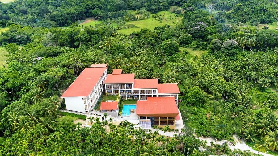 An elevated view of a resort building with a red roof nestled within a dense green forest. - Sea Hills Resort, Swaraj Dweep (Havelock)