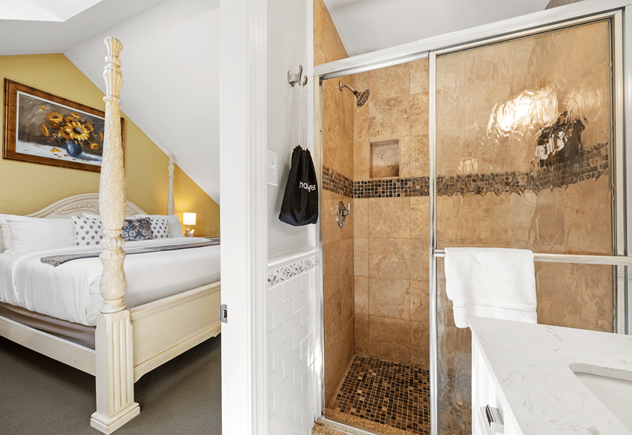 A split-view photo of a bedroom with a four-poster bed and a bathroom with a tiled shower and marble countertop.