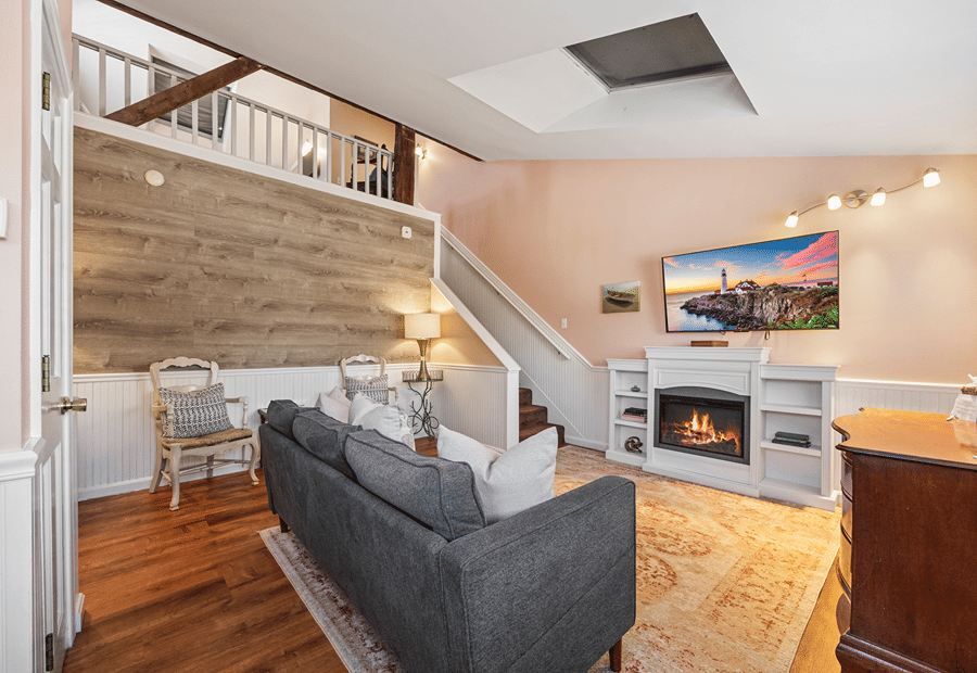 A cozy hotel lobby with a fireplace, TV, and sofa