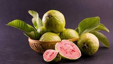Fresh figs alongside bottles and a prepared drink on a display.