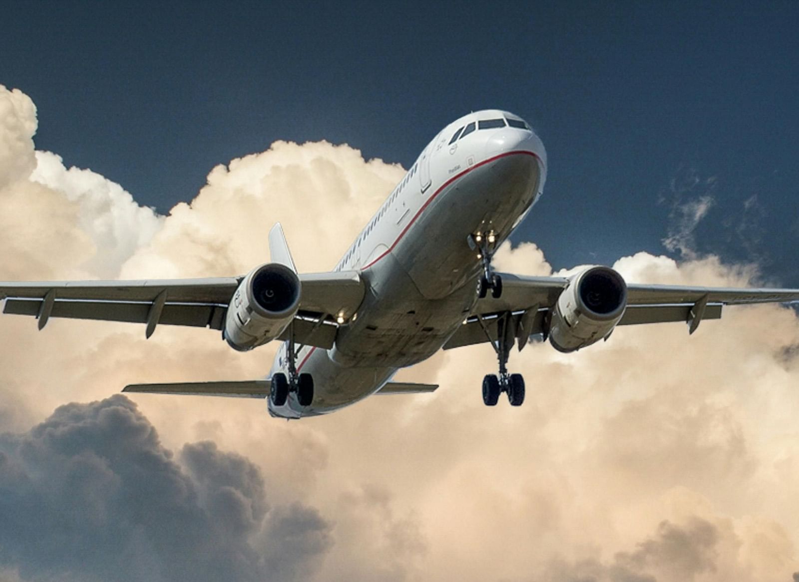 An aeroplane soaring against a cloudy sky.