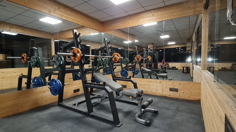 Modern gym equipment at Shaheen Bagh, set in a sleek mirrored workout space.