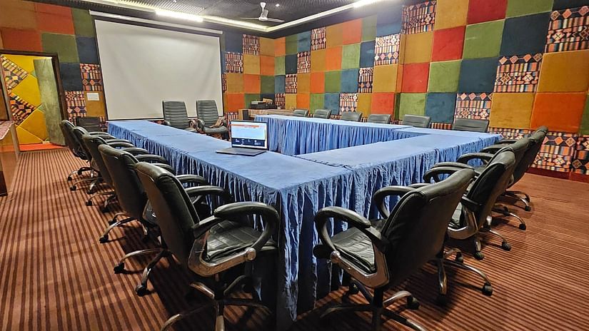 Image of a conference room featuring teh table and chairs arranged