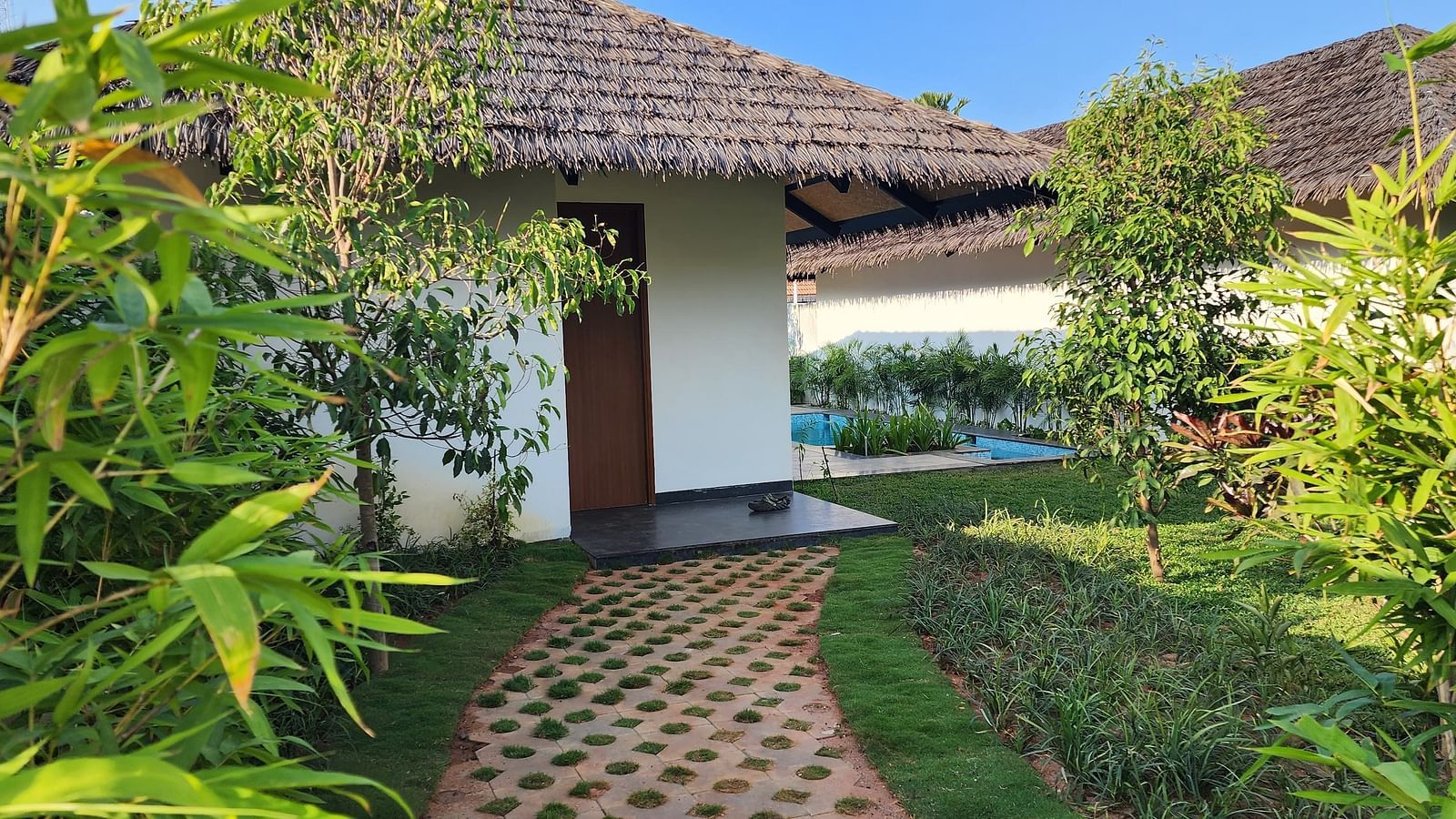 Exterior view of the Exotic Pool Villa with a pathway traversing through a beautiful garden at The Shore, Trishvam.