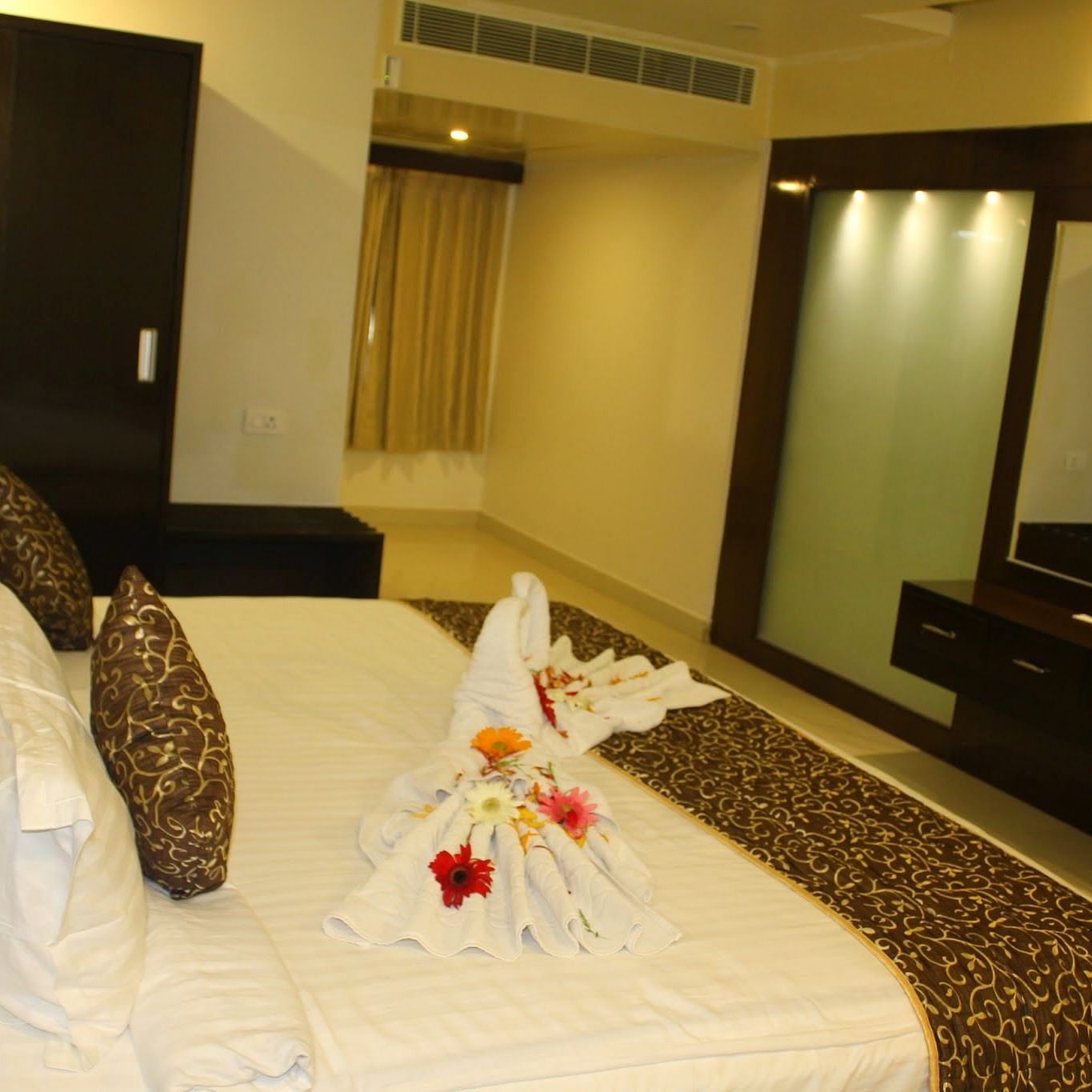 Side view of room with bed and dressing table in fornt at Living roon with sofas and a coffee table at Hotel Green Apple