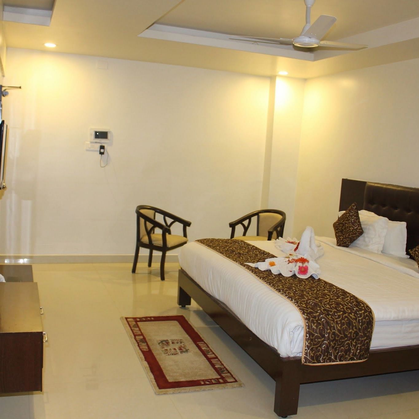 Room with bed, sitting area and television in front at Living roon with sofas and a coffee table at Hotel Green Apple
