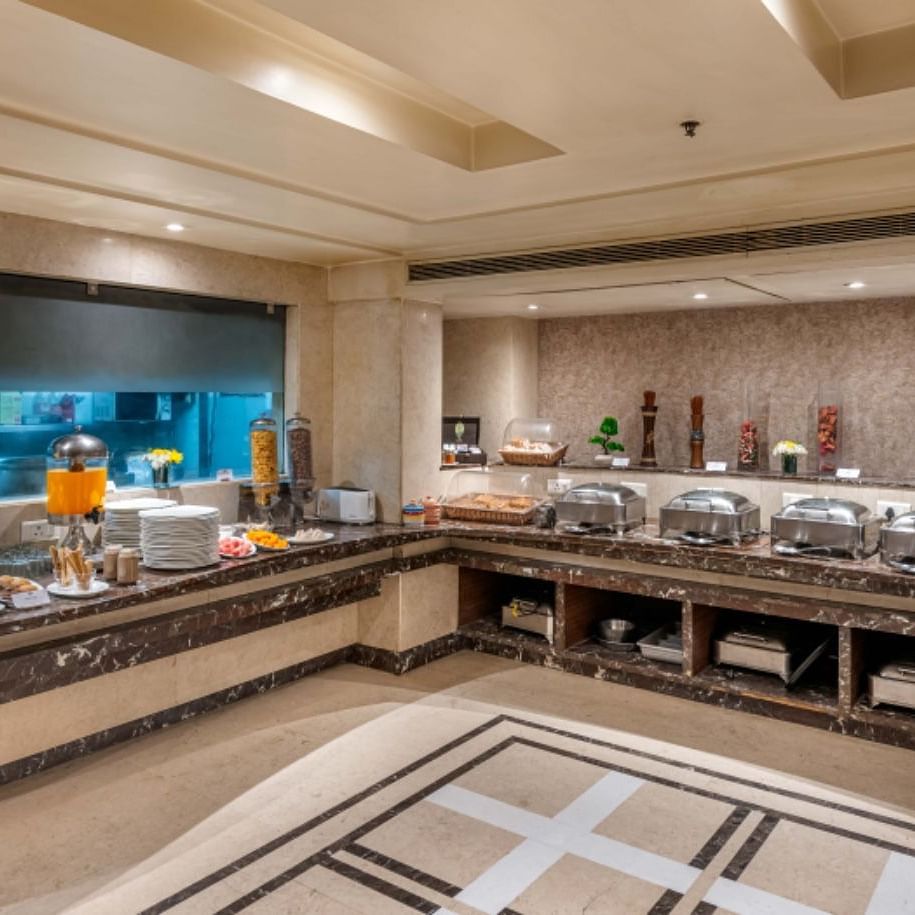 a breakfast buffet counter at Libra Lords Inn Jaipur with cereals, confectionaries and neatly arranged white ceramics