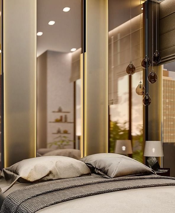 A room with chic and modern interiors with tall mirrors behind the bed.
